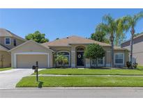 Charming single-story home featuring a well-manicured lawn, attached garage, and inviting front entrance at 3233 Russett Pl, Land O Lakes, FL 34638