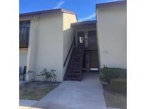 Exterior front view of condo unit with stairs leading to a second-story entrance at 4215 E Bay Dr # 1701B, Clearwater, FL 33764