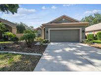 Charming one-story home featuring a well-manicured lawn and two-car garage at 4410 Sawgrass Dr, Palm Harbor, FL 34685