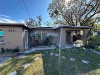 Charming single-story home featuring a covered porch and a well-maintained front yard with mature trees at 6411 N 34Th St, Tampa, FL 33610