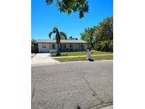 Charming single-story home with a well-manicured lawn and mature trees in a sunny neighborhood at 8588 95Th Ave, Seminole, FL 33777