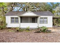 Charming single-story home with a screened-in porch and mature landscaping at 9025 Gronde Ave, Brooksville, FL 34601