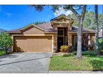 Charming single Gathering home featuring a two-car garage, well-maintained lawn, and manicured landscaping at 10222 Woodford Bridge St, Tampa, FL 33626