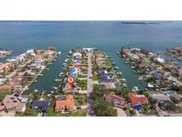 A serene aerial view shows the home's waterfront location with access to open water and boat docks at 137 11Th E St, Tierra Verde, FL 33715