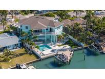 Stunning waterfront home with pool, boat dock, and lush tropical landscaping at 15904 Redington Dr, Redington Beach, FL 33708