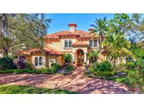 Stunning Mediterranean-style home featuring a red tile roof and meticulously landscaped front yard at 16205 Sierra De Avila, Tampa, FL 33613