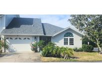 Charming home featuring an attached garage, well maintained landscaping, and a welcoming entrance at 11722 Currie Ln # E1, Largo, FL 33774
