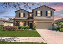 Charming two-story home with a well-manicured lawn and attached two car garage in a suburban neighborhood at 2208 Landside Dr, Valrico, FL 33594