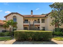 Charming two-story condo with a red tile roof, private balconies, and mature landscaping at 2632 Enterprise E Rd # A23, Clearwater, FL 33759