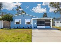 Charming light blue single-story home with a well-maintained front yard and screened porch at 358 51St N Ave, St Petersburg, FL 33703