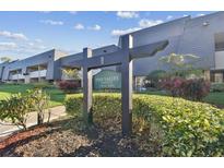 Pine Valley Lodge condo exterior with signage and professional landscaping under a sunny blue sky at 36750 Us Highway 19 N # 19308, Palm Harbor, FL 34684
