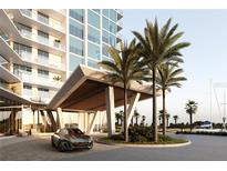 Modern building entrance with porte cochere, palm trees and luxury vehicle at 5120 Marina Way # 21206, Tampa, FL 33611