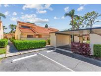 Charming home exterior featuring a red tile roof, lush landscaping, and a convenient carport at 5310 Huntingwood Ct # 40, Sarasota, FL 34235
