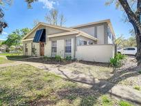 Charming home featuring a modern awning over the front door, complemented by manicured landscaping and a welcoming walkway at 6218 Greenleaf Ln # 6218, Temple Terrace, FL 33617