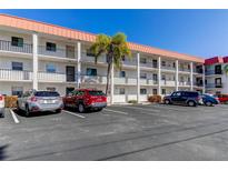 Three story condo with a parking lot in front and a large palm tree at 10530 77Th Ter # 224, Seminole, FL 33772
