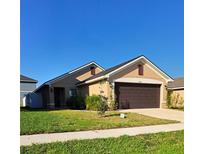 Charming one-story home featuring a well-maintained lawn and a two-car garage at 13052 Ogden Glade Rd, Dade City, FL 33525