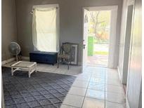 Cozy living room featuring an area rug, window, and doorway leading outside at 2410 Harper St, Tampa, FL 33605