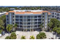 Stunning condo building featuring a terracotta roof, white accents and multiple levels of balconies overlooking lush landscaping at 3805 Gulf Blvd # 404, St Pete Beach, FL 33706