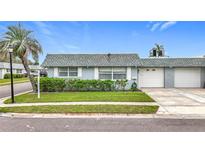 Charming single story home with manicured front lawn, attached garage, and traditional shuttered windows at 504 Cara Ct # 504, Largo, FL 33771