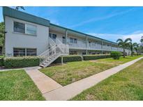 Well-maintained condo exterior featuring multiple units, landscaped grounds, and stair access to upper levels at 5267 81St N St # 18, St Petersburg, FL 33709