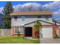 Charming two-story home with a brick facade, well-manicured lawn, and an American flag at 531 Luzon Ave, Tampa, FL 33606