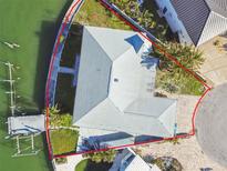 Aerial view of home with a gray roof, lush landscaping, and a private dock, all within a waterfront community at 13 Bellevue Dr, Treasure Island, FL 33706