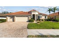 Charming single Gathering home featuring a well-manicured lawn and a three-car garage at 2769 Harvest Drive, Sarasota, FL 34240