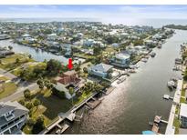 Stunning aerial view of a waterfront community with lush landscaping and canal access to the open bay and Gulf of Mexico at 3447 Flamingo Blvd, Hernando Beach, FL 34607