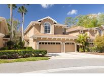Charming home featuring a two-car garage, manicured landscaping, and a welcoming front entrance at 4216 Preserve Pl, Palm Harbor, FL 34685