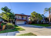 Charming two-story home featuring a spacious front porch, complemented by lush landscaping and a well-manicured lawn at 510 Pine S Ave, Oldsmar, FL 34677