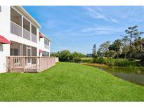 Spacious backyard with a green lawn and scenic water view, ideal for outdoor activities and relaxation at 1400 Water View W Dr # 102, Largo, FL 33771