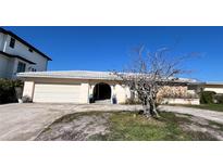 Charming single-story home featuring a neutral color palette, an arched entrance, and a two-car garage at 16217 Redington Dr, Redington Beach, FL 33708