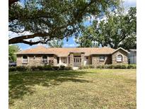 Charming single-story brick home with a spacious front yard and mature tree, perfect for outdoor enjoyment at 1811 Tawnee Pl, Brandon, FL 33510