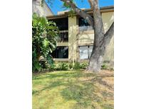 Two-story condo with screened in lanai, lush landscaping, and mature tree shading the building at 247 Woodlake Wynde, Oldsmar, FL 34677