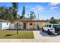 Charming single-story home features a well-maintained lawn, a white jeep, and a cozy covered porch at 350 51St N Ave, St Petersburg, FL 33703