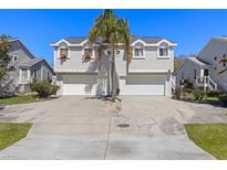 Charming townhome with a two-car garage, nice curb appeal, and a central palm tree at 525 Oceanview Ave, Palm Harbor, FL 34683