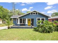 Charming blue bungalow with a bright yellow front door and a cozy front porch at 5915 N Otis Ave, Tampa, FL 33604