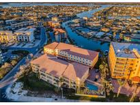 Stunning aerial view of a condominium community with a pool and waterfront access to the intercoastal waterway at 11595 Gulf Blvd # 6, Treasure Island, FL 33706