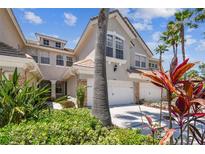 Charming multi-story home with a two-car garage, landscaped yard, and tropical foliage at 14542 Mirabelle Vista Cir, Tampa, FL 33626