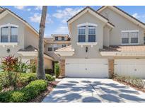 Charming two-story townhouse featuring an attached garage, manicured landscaping, and a tile roof at 14542 Mirabelle Vista Cir, Tampa, FL 33626