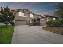 A charming two-story home with a spacious three-car garage and well-manicured landscaping at 501 Washita Stone Dr, Ruskin, FL 33570