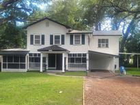 Charming two-story home with black shutters, front porch, driveway, and mature trees at 5121 40Th N Ave, St Petersburg, FL 33709