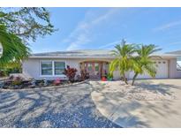 Charming single-story home featuring lush landscaping, a well-manicured lawn, and a welcoming entryway with double doors at 6324 Balboa Ln, Apollo Beach, FL 33572