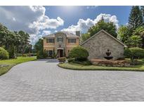 Elegant home featuring a stone turret, manicured landscaping, and a circular driveway at 8711 Brooke Angela Dr, Odessa, FL 33556