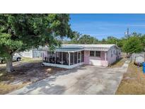 Charming home featuring a screened porch, covered entry, and spacious driveway at 9048 94Th St, Seminole, FL 33777