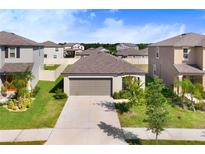 Charming single-Gathering home with a well-manicured front lawn and attached garage at 9412 Lemon Drop Loop, Ruskin, FL 33573