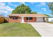 Charming brick home featuring an attached carport and a well-manicured front lawn at 10323 107Th N Ave, Largo, FL 33773