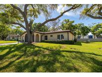 Charming single-story home with a lush green lawn and mature shade trees at 12200 Vonn Rd # 6D, Largo, FL 33774