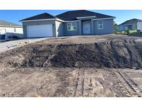 Charming single-story home with gray exterior, a two-car garage, and a freshly landscaped front yard at 13195 Drysdale Ave, Port Charlotte, FL 33981