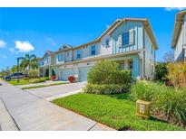 Charming townhome exterior with manicured lawns, beautiful landscaping, and attached garages on a bright, sunny day at 2270 Spring Lake Ct, Clearwater, FL 33763
